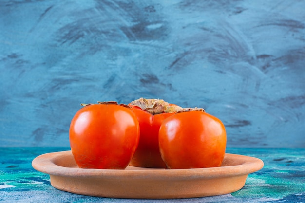 Persimmons in a clay plate 