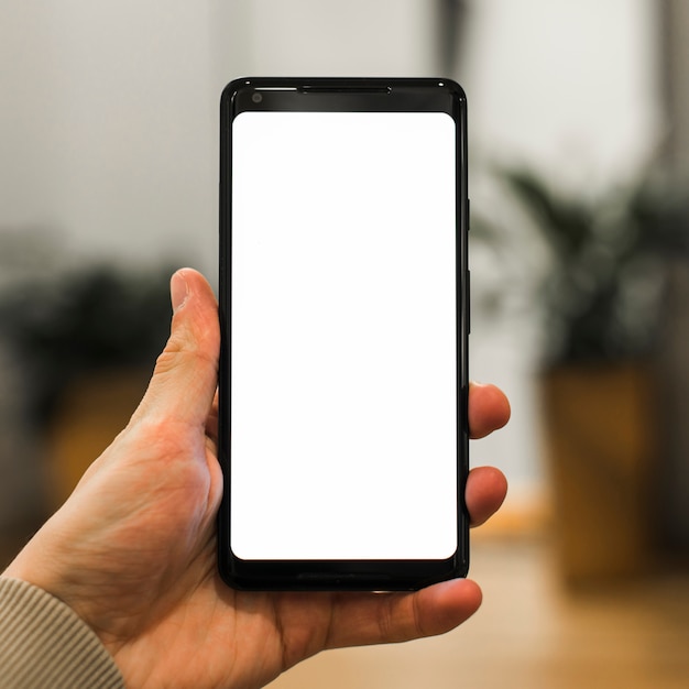 A person advertising his new smartphone against blurred backdrop