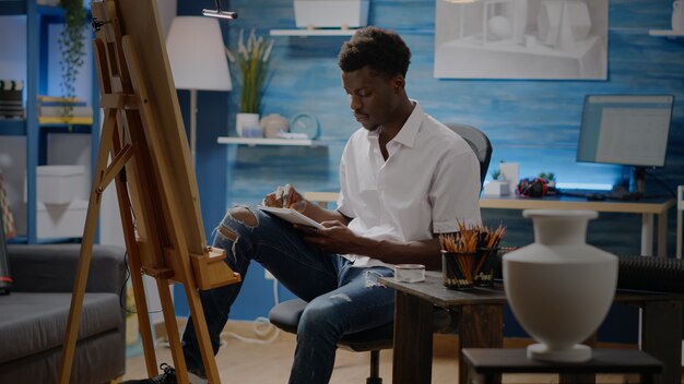 Person of african american ethnicity working on vase sketch