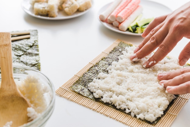 Person arranging rice layer