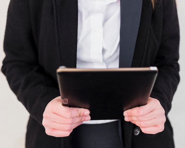 Free photo person in black jacket using tablet