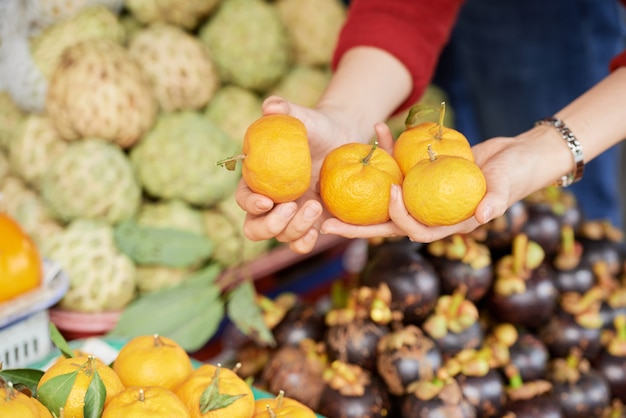 Foto gratuita persona che compra mandarini maturi