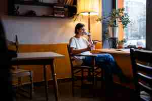 Free photo person in a cafe enjoying a book