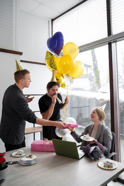 Free photo person celebrating birthday at office