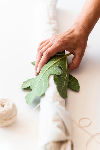 Person coloring a cloth with leaves close up