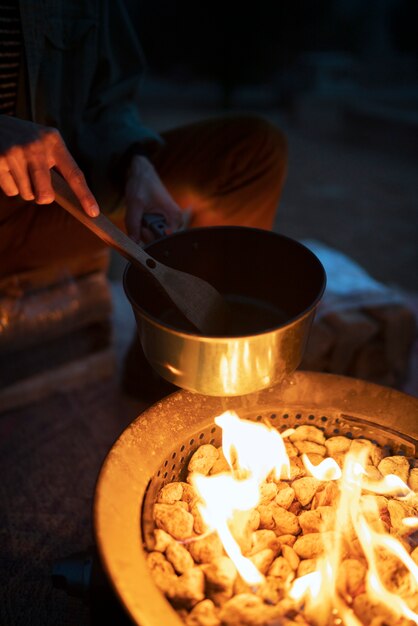 Person cooking at fire camp