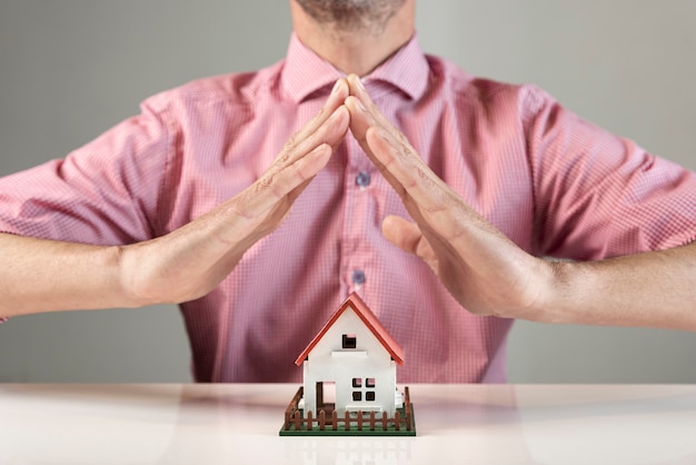 Foto gratuita persona che crea un tetto per la casa con le mani