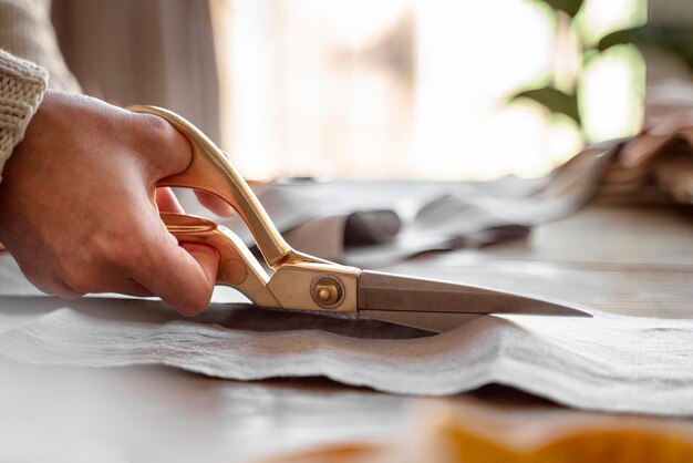 person cutting fabric for sewing
