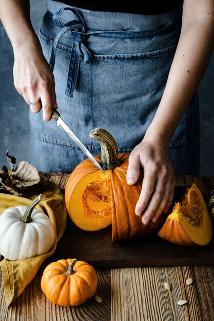 Person cutting Halloween pumpkin