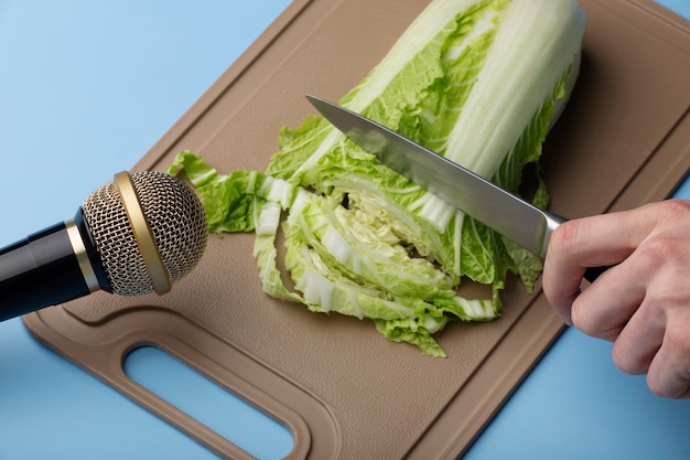 Person cutting iceberg lettuce close to microphone for asmr