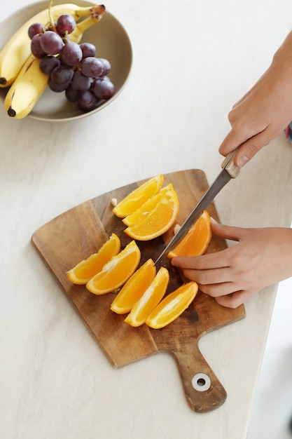 Person cutting orange slices