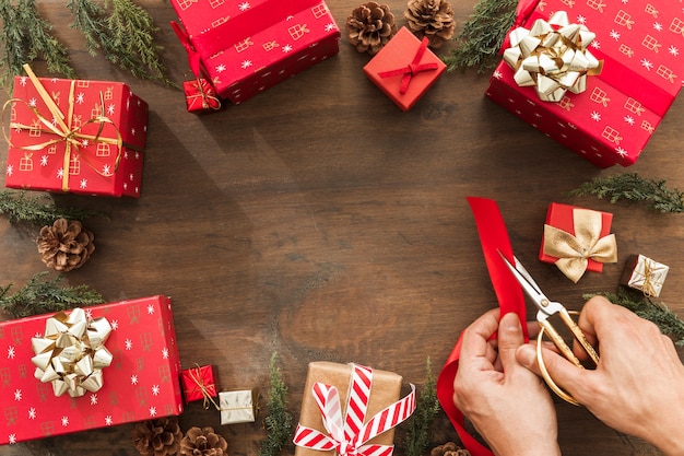 Person cutting red ribbon on brown table