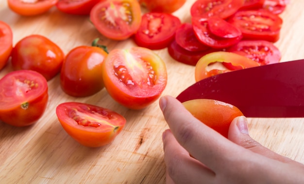 スライスしたトマトを切る人