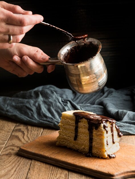 溶かしたチョコレートでケーキを飾る人