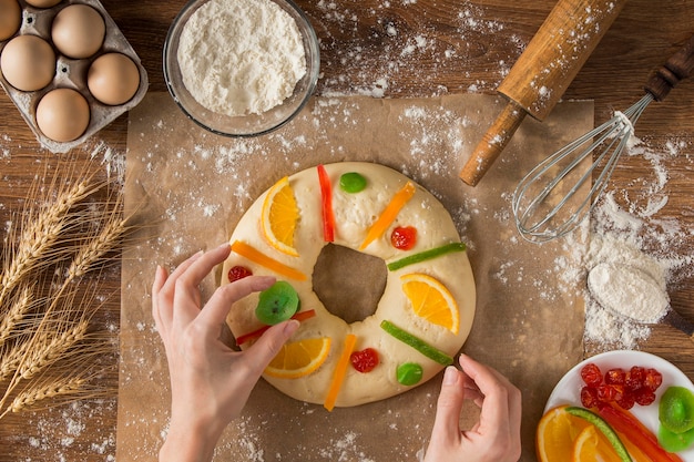 Foto gratuita persona che decora la torta dell'epifania roscon de reyes