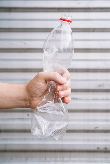 Person destroying a plastic bottle