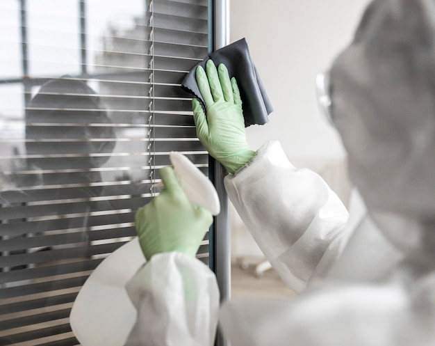 Foto gratuita persona che disinfetta un'area pericolosa mentre indossa una tuta protettiva