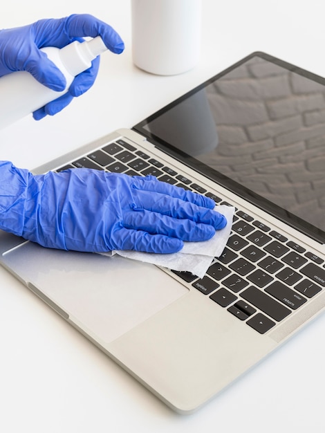 Free photo person disinfecting a laptop