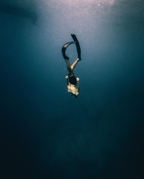 Person diving deep in mediterranean sea Premium Photo