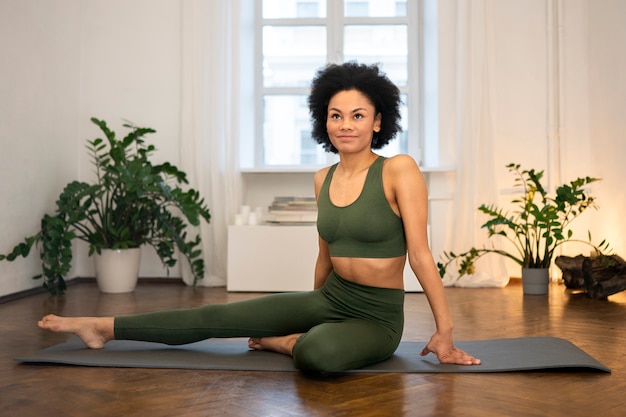 Free photo person doing yoga accompanied by her pet