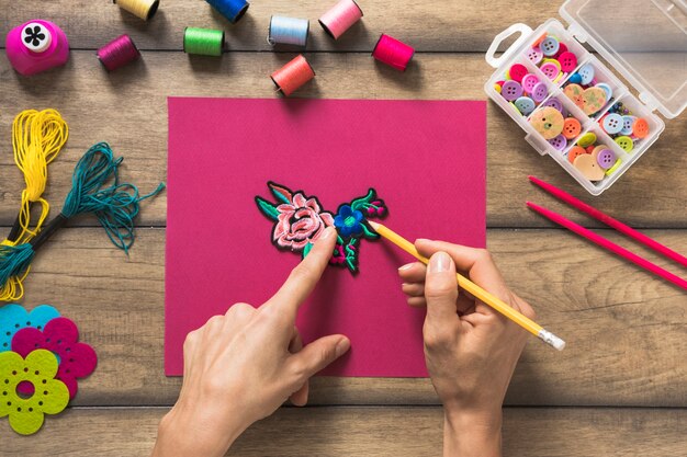 A person drawing outline around the patch on pink paper