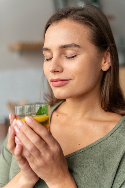 Person drinking kombucha at home in the kitchen