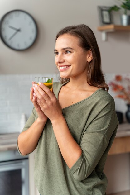 Person drinking kombucha at home in the kitchen
