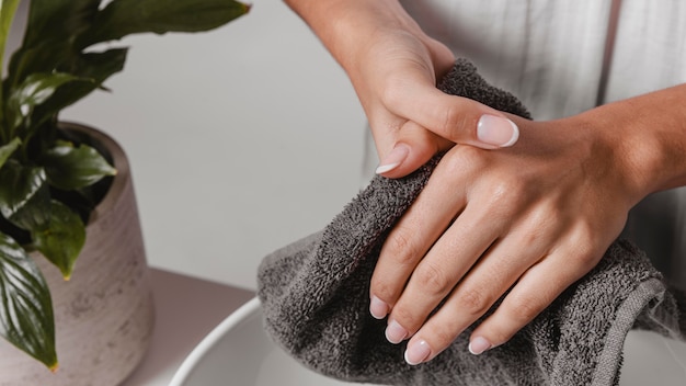 Free photo person drying her hands on a towel close-up