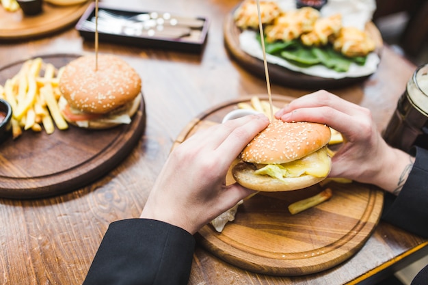 Person eating hamburger in restaurant