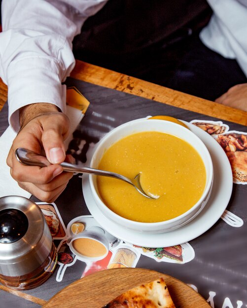 レンズ豆のスープを食べる人