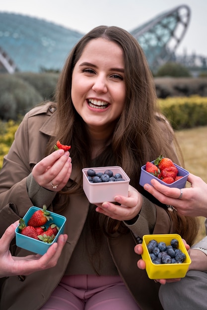 Foto gratuita persona che gode di uno spuntino di bacche all'aperto