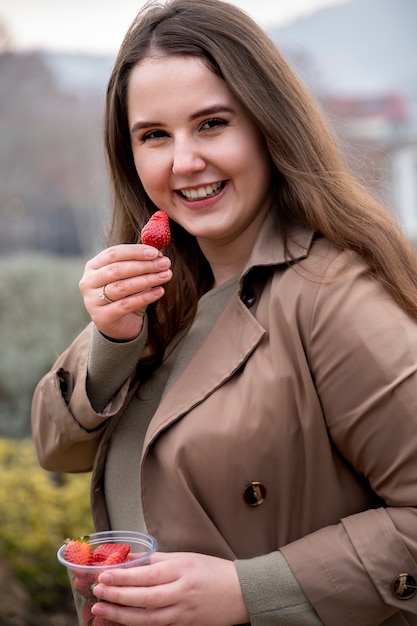 Foto gratuita persona che gode di uno spuntino di bacche all'aperto