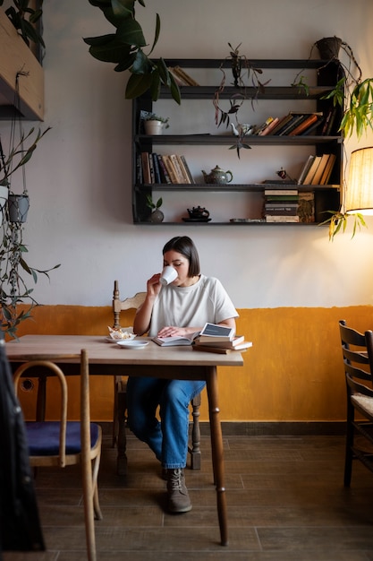 Foto gratuita persona che si diverte a leggere un libro in un caffè