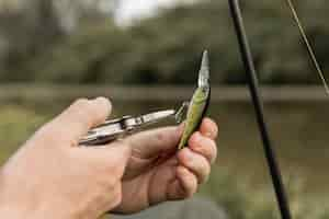 Free photo person fixing a fish hook