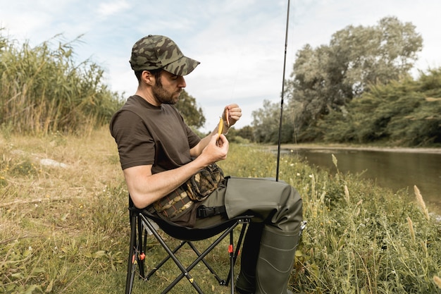 Free photo person fixing a fish hook