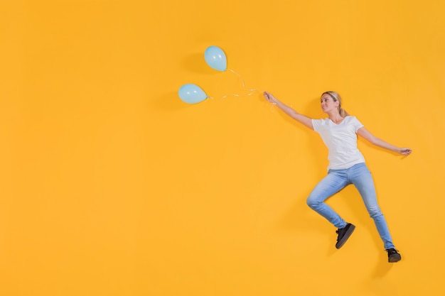 Person floating with blue balloons