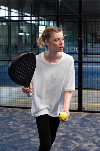 Person getting ready to play paddle tennis inside