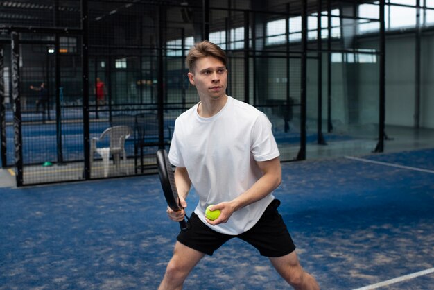 Person getting ready to play paddle tennis inside