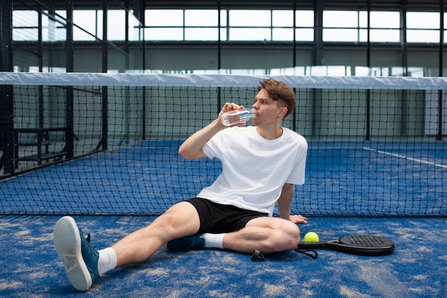 Foto gratuita persona che si prepara a giocare a paddle tennis all'interno