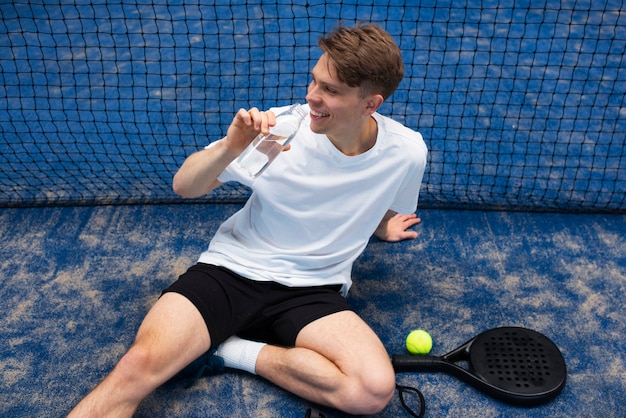 Person getting ready to play paddle tennis inside