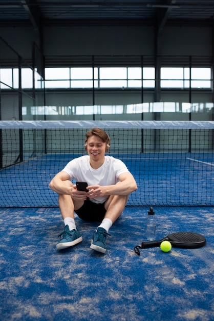 Foto gratuita persona che si prepara a giocare a paddle tennis all'interno