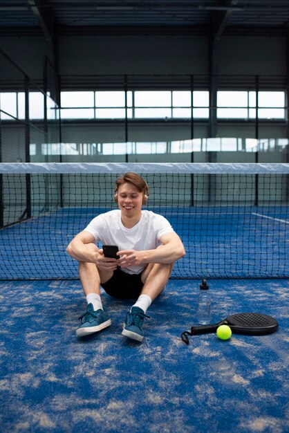 Person getting ready to play paddle tennis inside