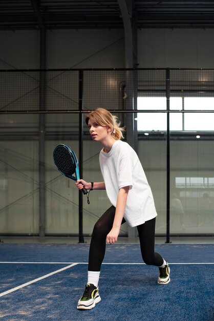 Person getting ready to play paddle tennis inside