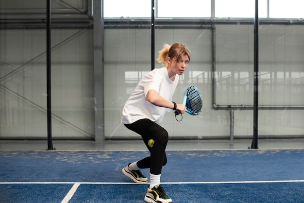 Person getting ready to play paddle tennis inside