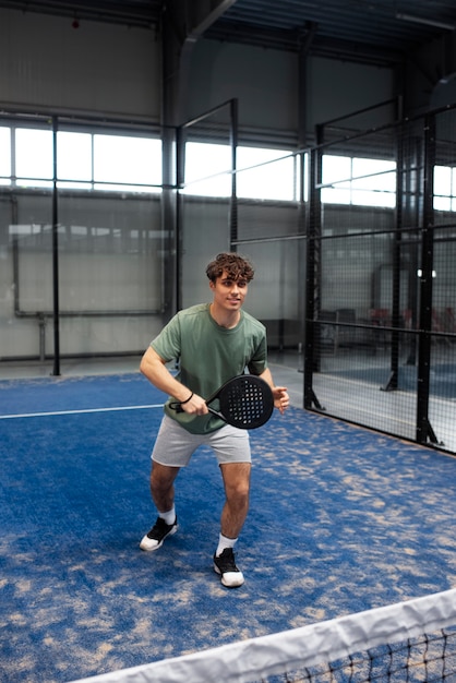 Person getting ready to play paddle tennis inside