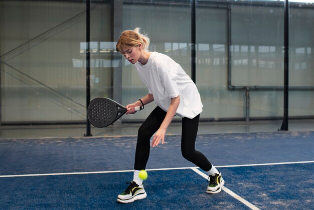 Person getting ready to play paddle tennis inside