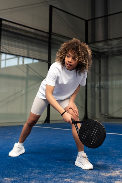 Person getting ready to play paddle tennis inside