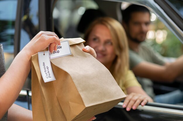 Person giving an order to a customer at a curbside pickup