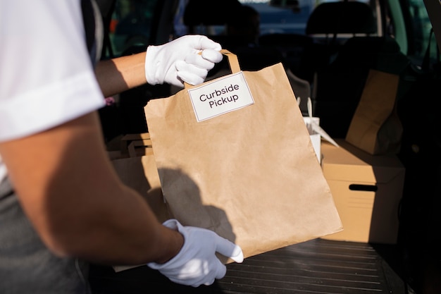 Foto gratuita persona che effettua un ordine a un cliente durante un ritiro a bordo strada