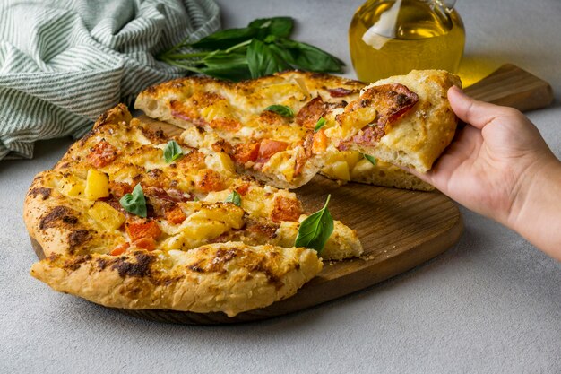 Person grabbing delicious pizza slice